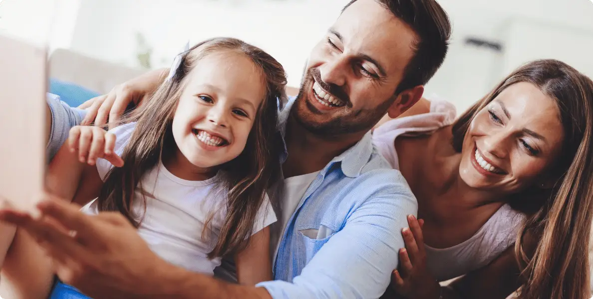 un couple avec un enfant regarde un ordinateur, ils semblent apprendre une bonne nouvelle concernant leur projet immobilier